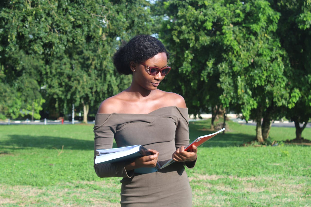 Young woman reading outdoors in Kumasi, Ghana. A sunny day for focused learning.